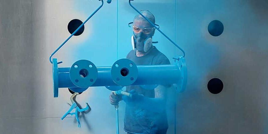 Aufnahme der Arbeiten bei einer Epoxy-Pulverbeschichtung mit Atemschutzmasken und Anzügen