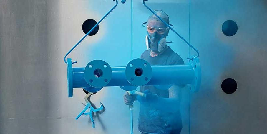 Aufnahme der Arbeiten bei einer Epoxy-Pulverbeschichtung mit Atemschutzmasken und Anzügen